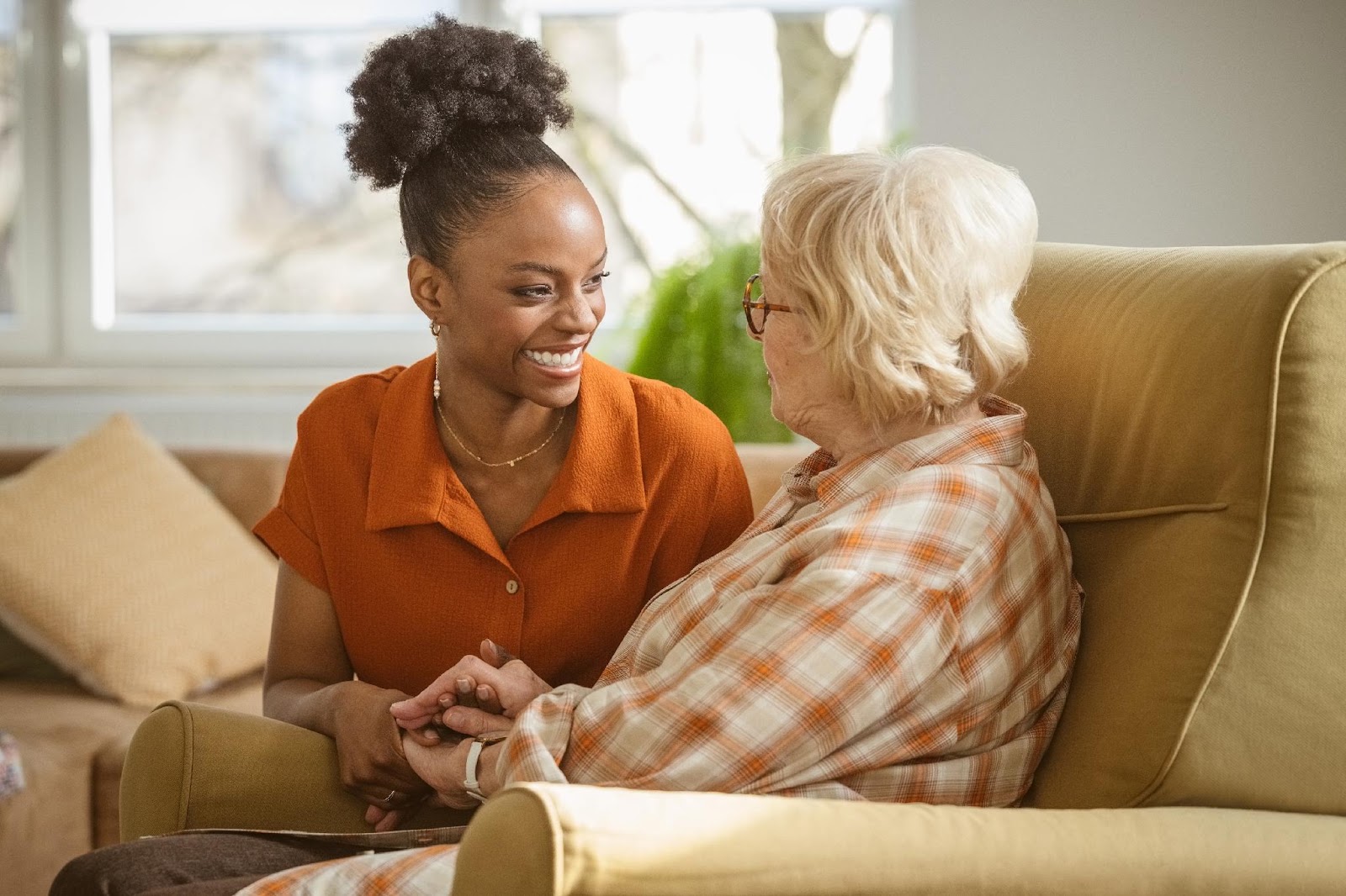 A live-in carer sharing a warm moment with an older woman at home