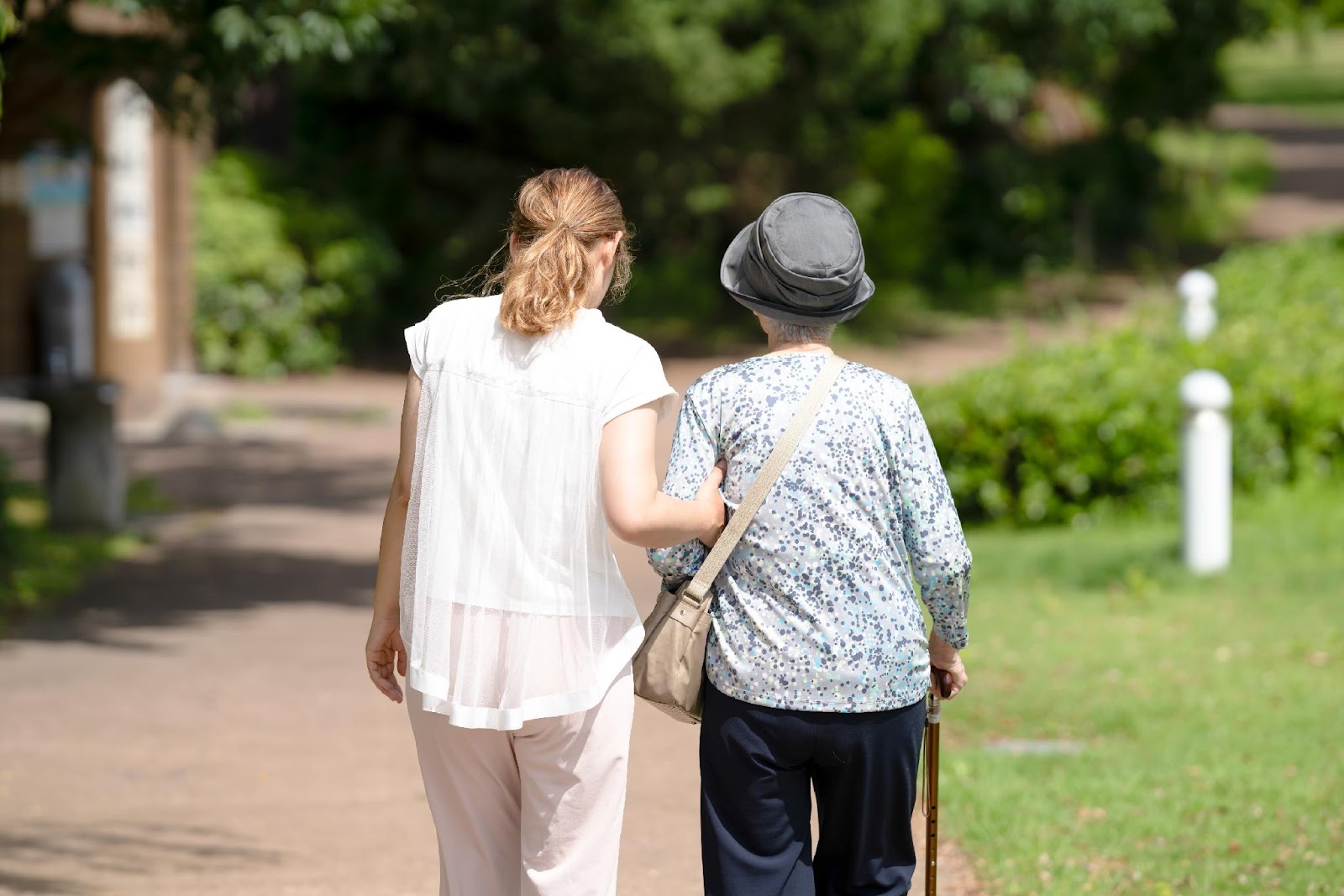 A woman walking outdoors with an older woman